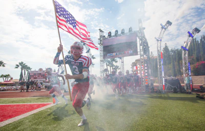 man in white and red jersey shirt holding flag of america
