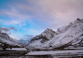 snow covered mountain under cloudy sky during daytime