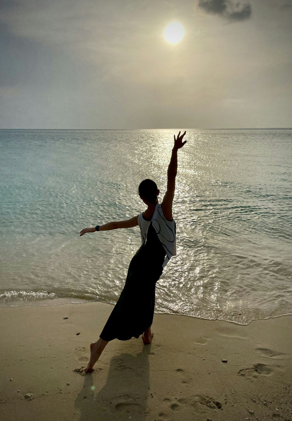 woman in white and black dress standing on beach during daytime