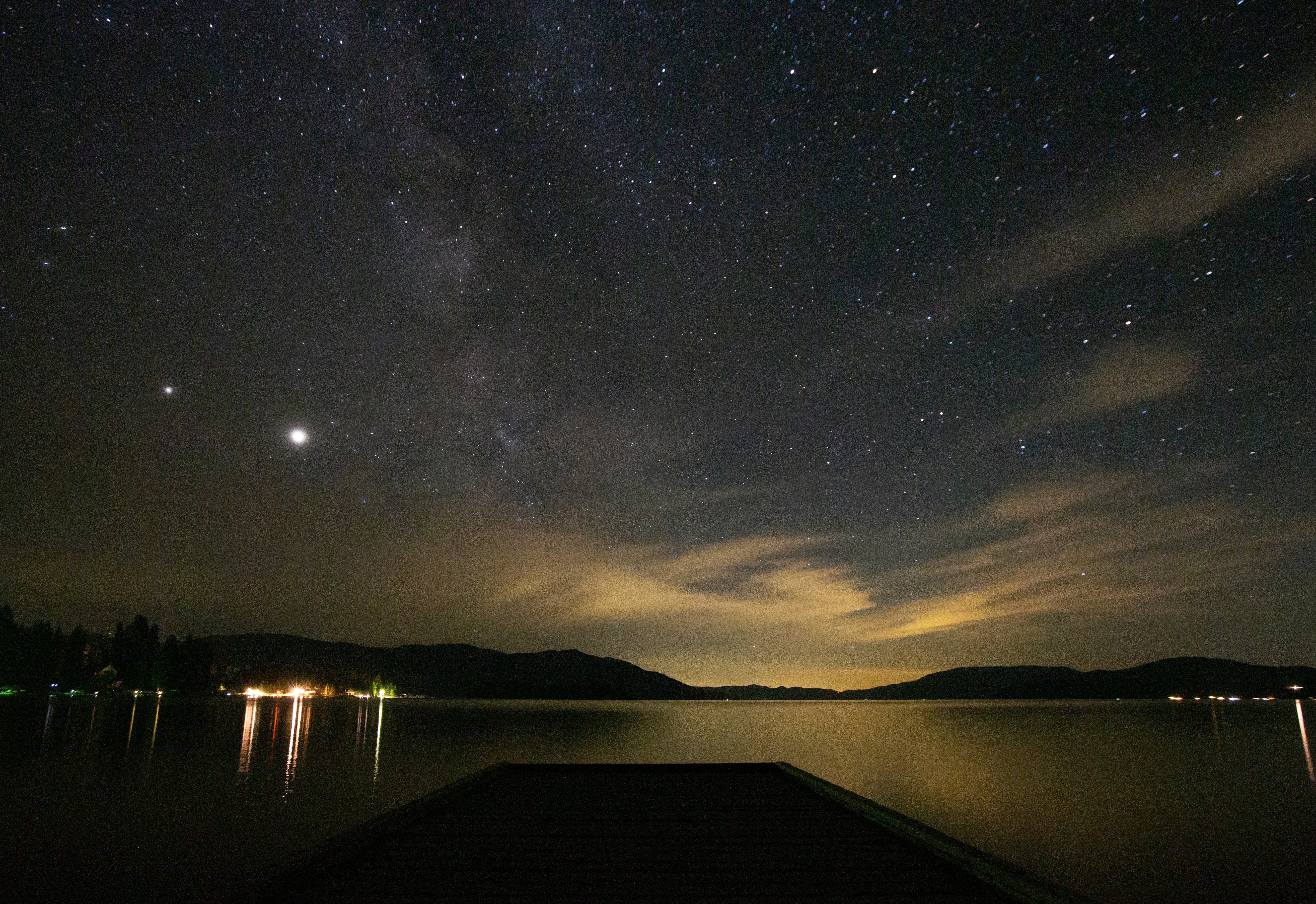 body of water near dock under starry night, Long exposure shot over Lake Pend Oreille in North Idaho with a brilliant night time sky.