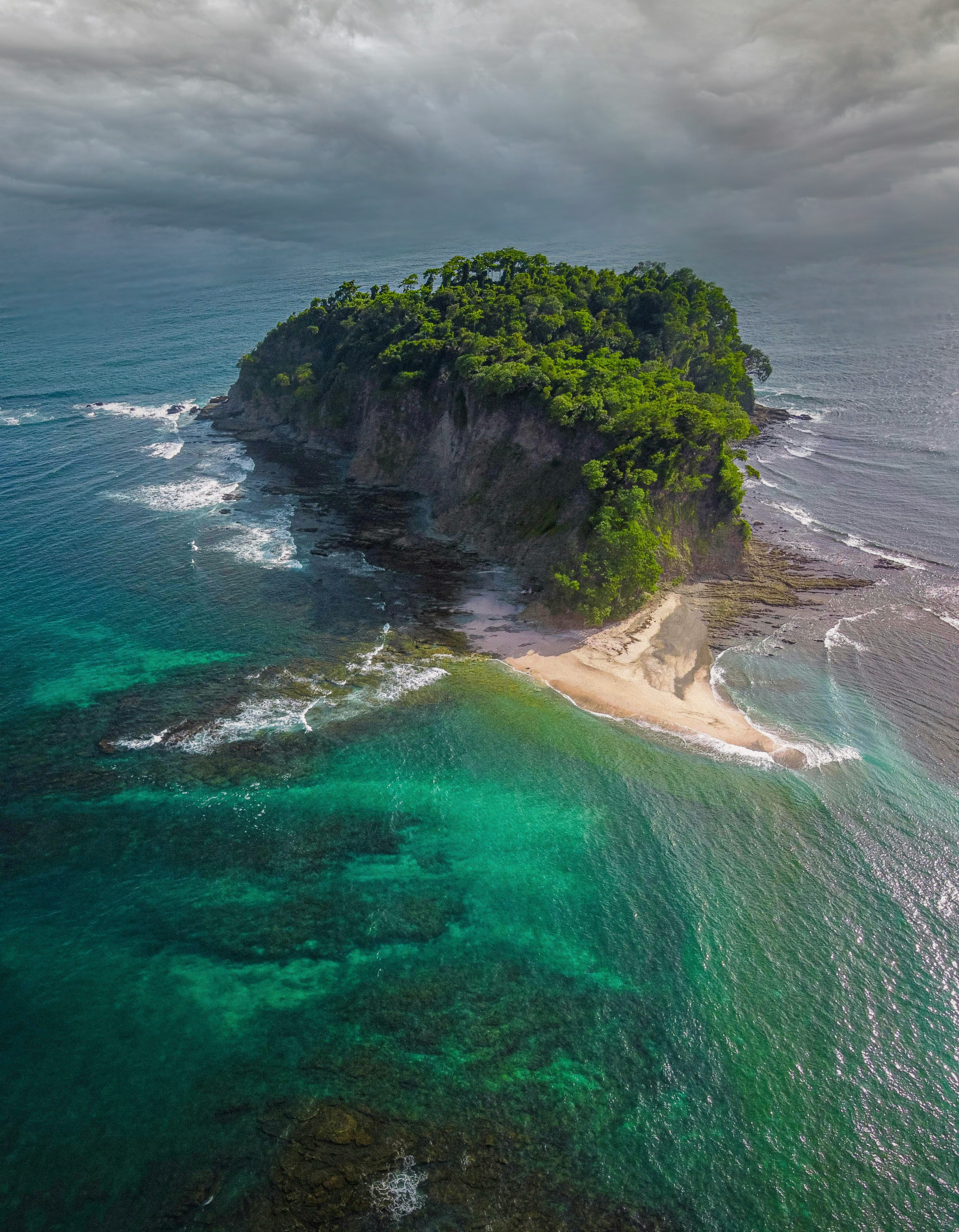 green and brown island in the middle of the sea