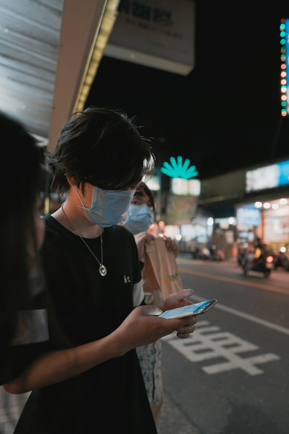 woman in black shirt holding smartphone