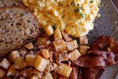 A beautifully arranged breakfast platter with eggs, bread, and fresh vegetables.
