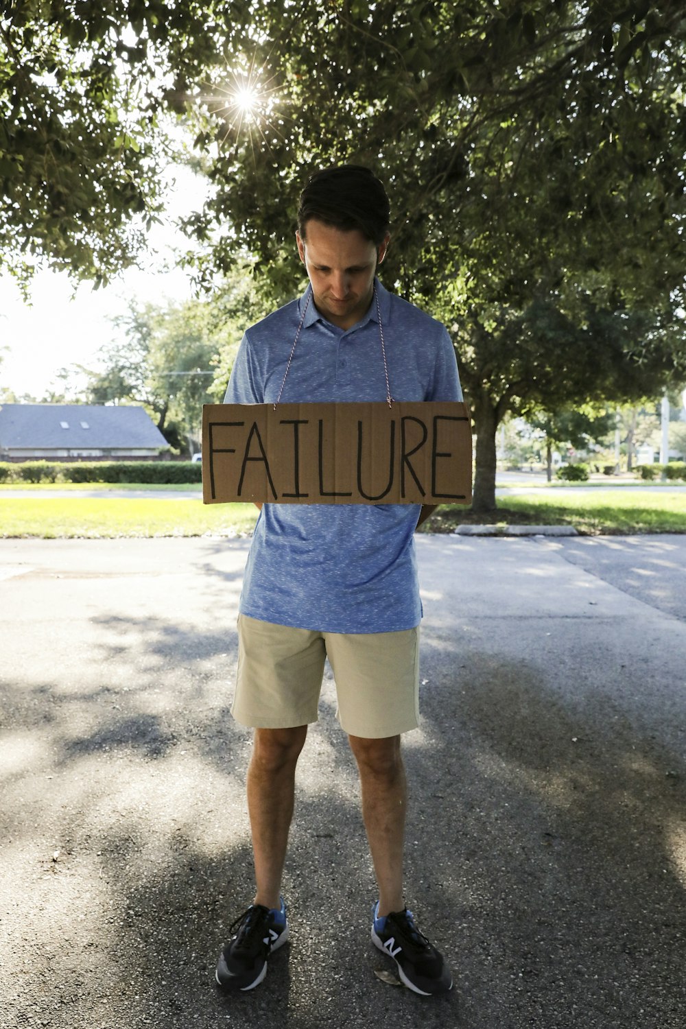 man in blue and white crew neck t-shirt holding brown wooden signage