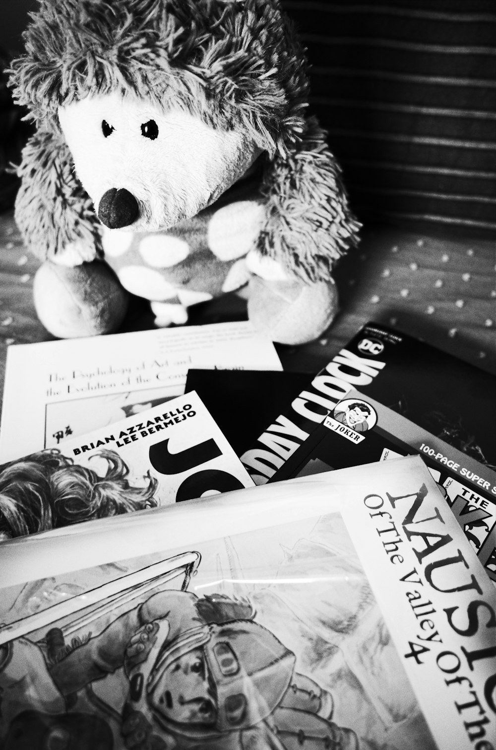 grayscale photo of bear plush toy on book