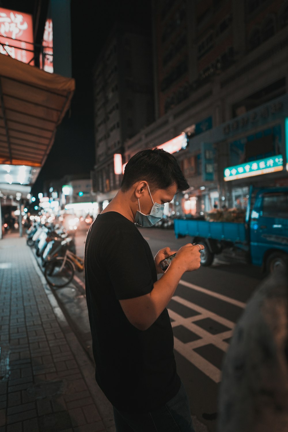 man in black t-shirt holding smartphone