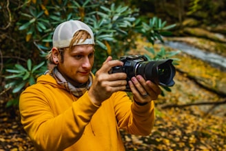 man in yellow jacket holding black dslr camera