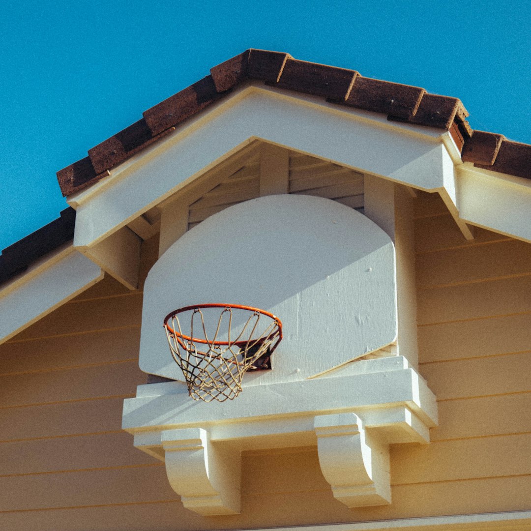 white and black basketball hoop on white wooden house