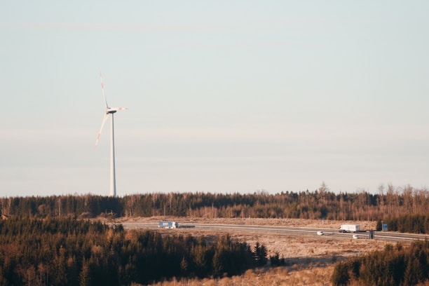 A fleet of trucks transporting wind turbine components on a highway.