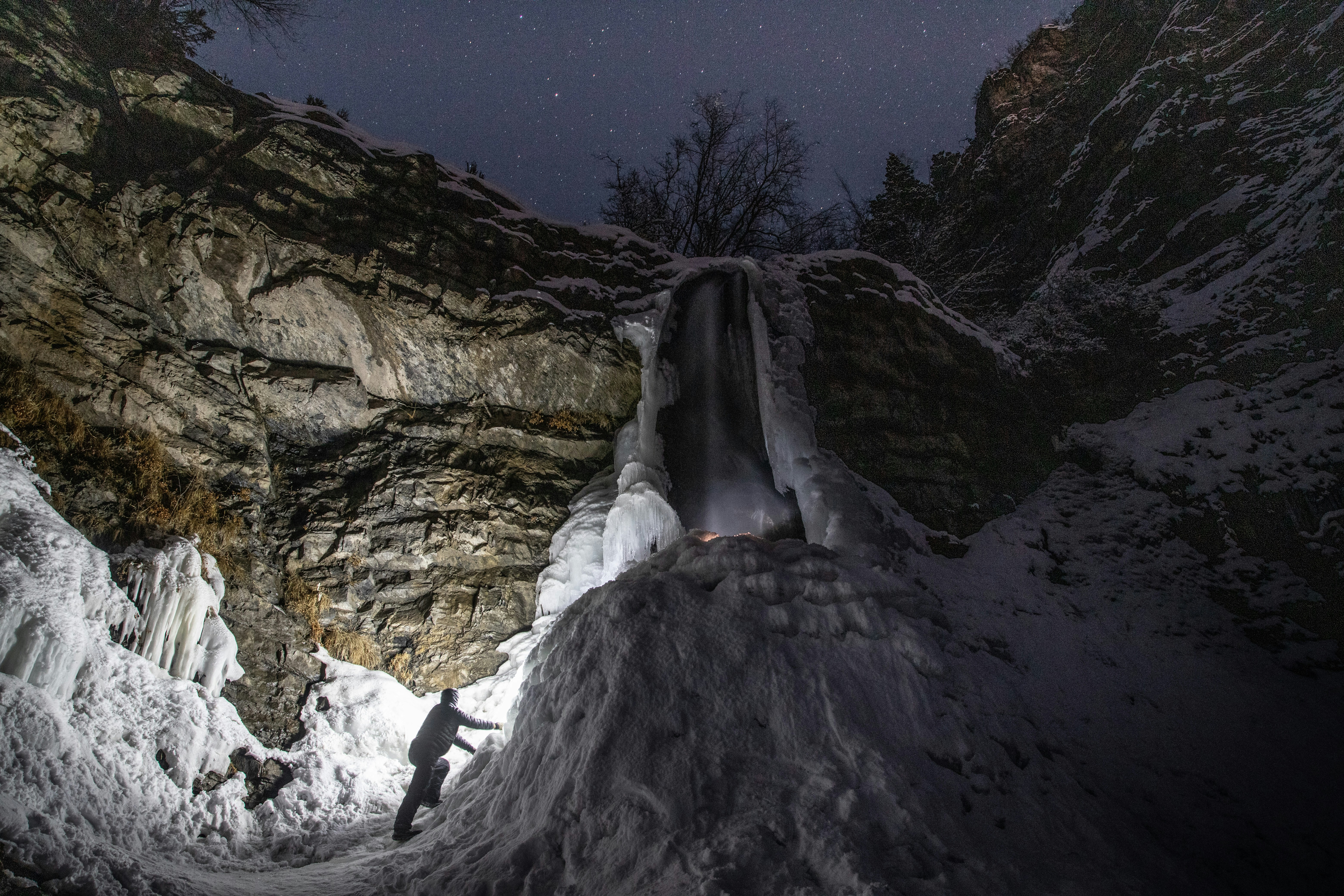person in white shirt standing on rock formation during daytime