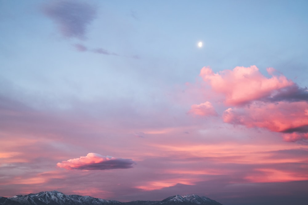 silhouette of mountain under cloudy sky during sunset