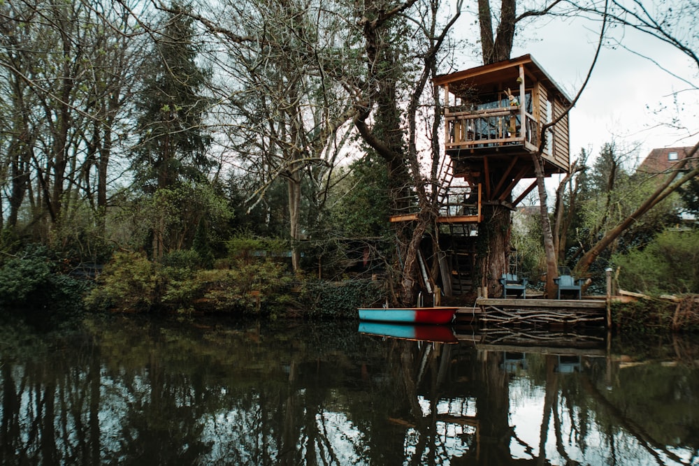 Rotes Boot auf dem See in der Nähe von Bäumen während des Tages