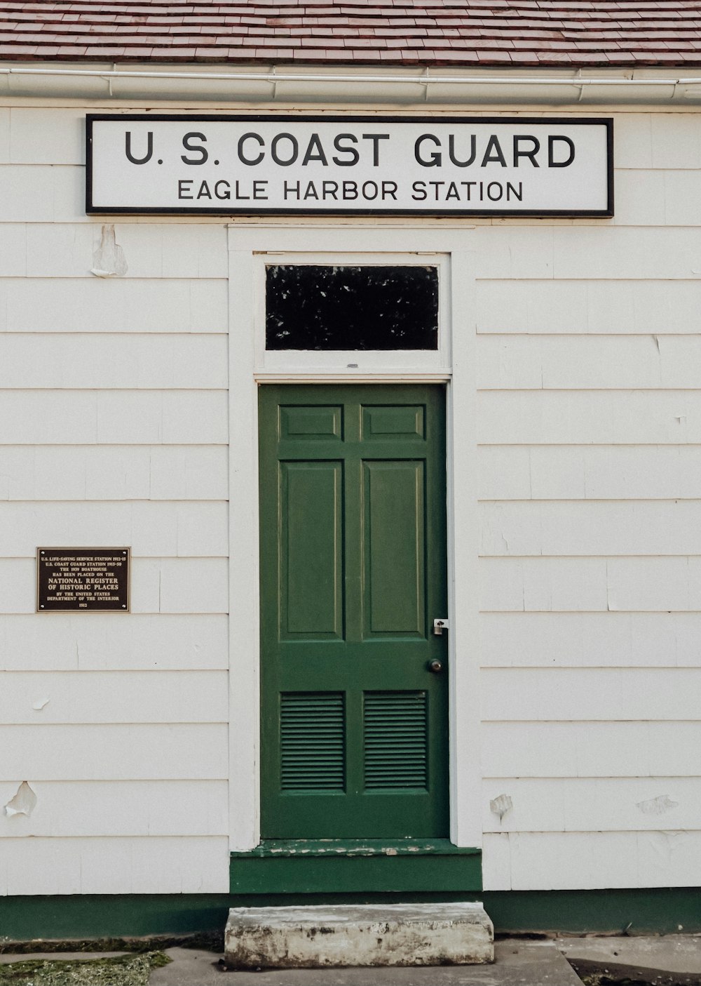 green wooden door with white wall