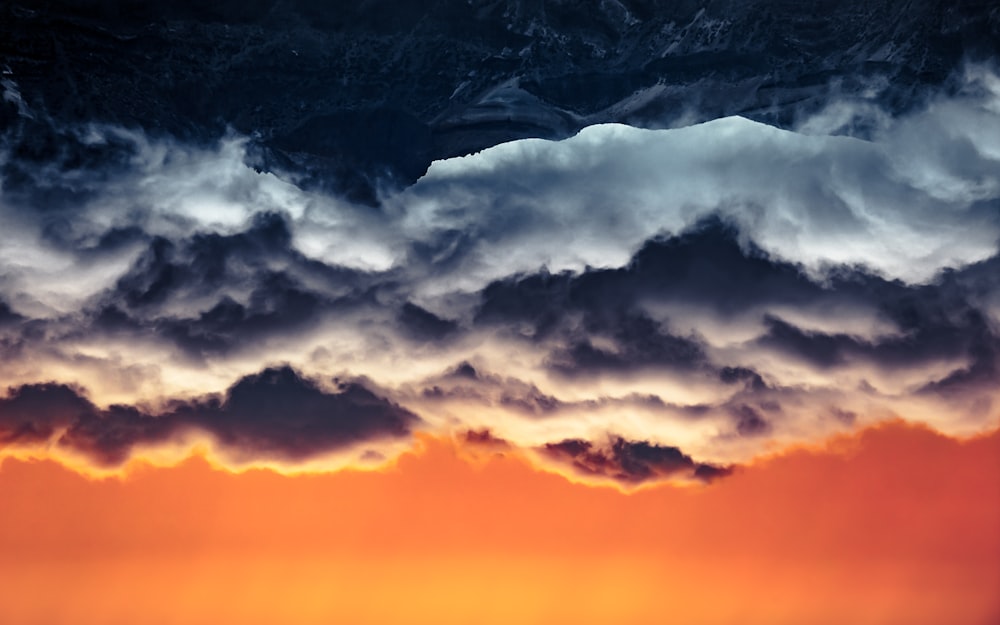 black and white mountain under white clouds