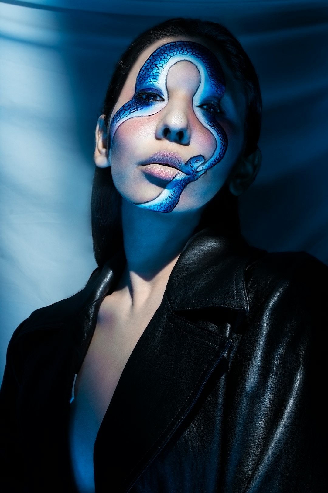 woman in black leather jacket with blue face paint