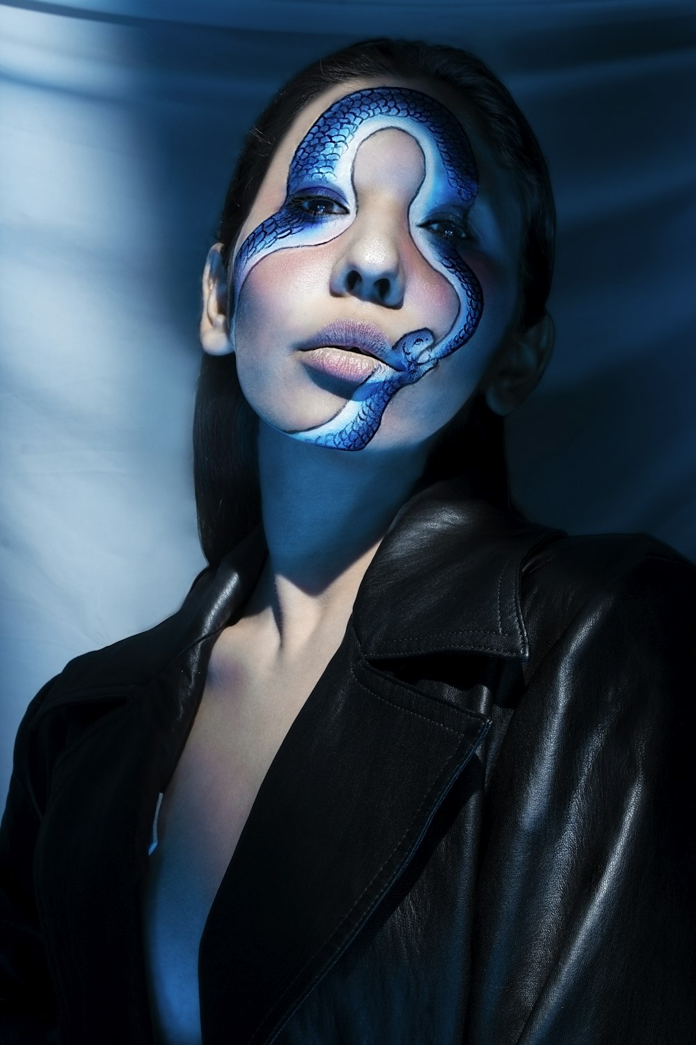 woman in black leather jacket with blue face paint