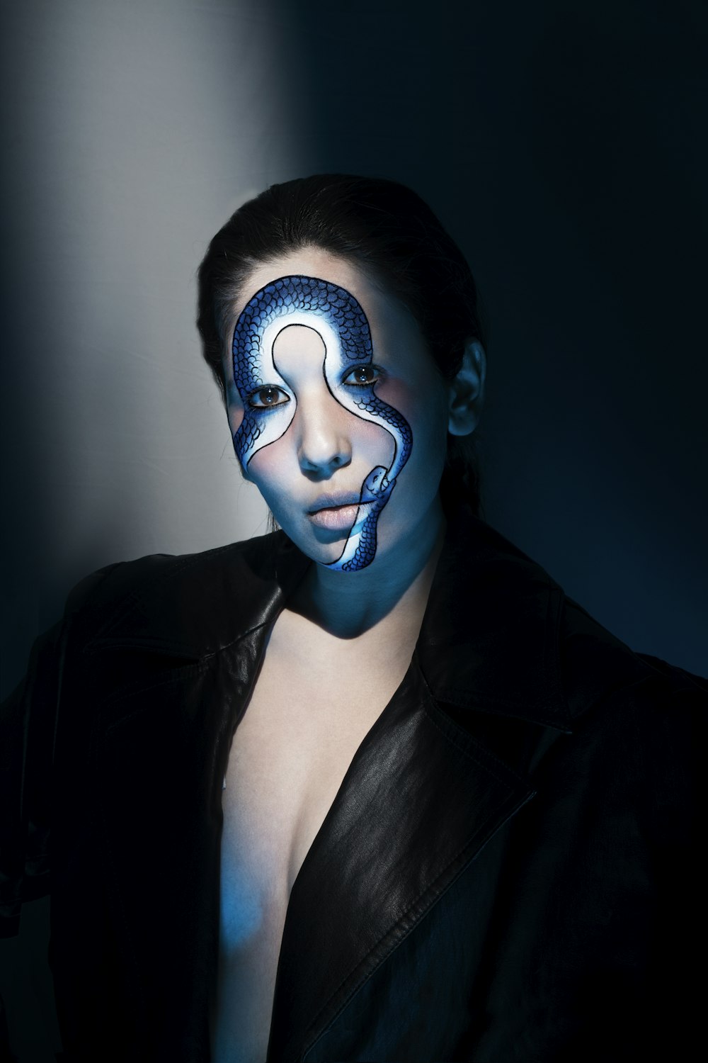 woman in black blazer with blue and black face paint