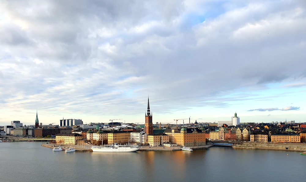 Braunes und weißes Betongebäude in der Nähe von Gewässern unter weißen Wolken tagsüber