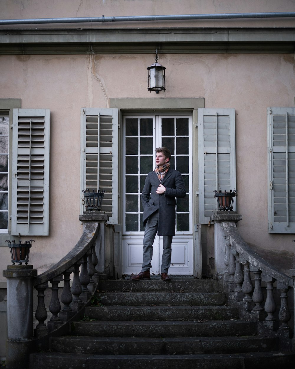 man in black suit standing on staircase