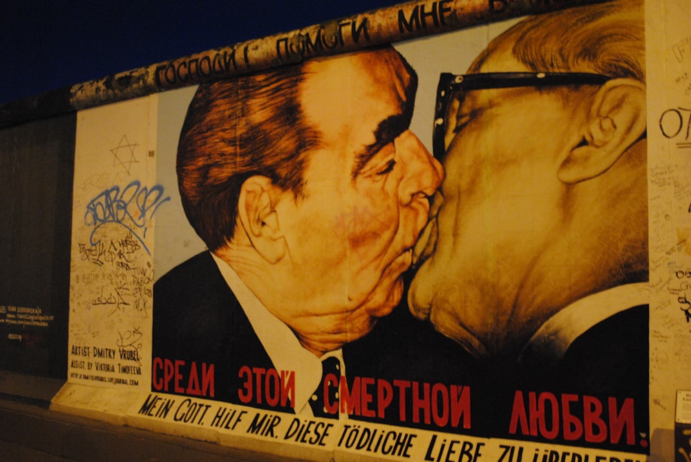 a large mural of two men kissing each other