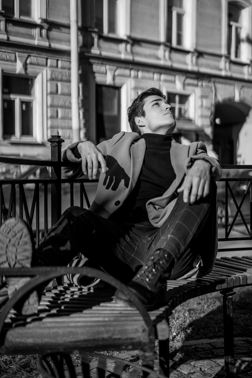 man in black and white crew neck t-shirt and black pants sitting on bench