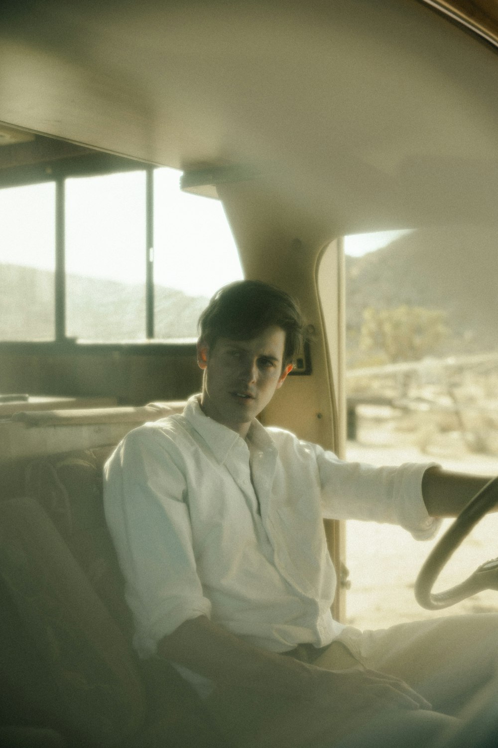 man in white dress shirt sitting on car seat