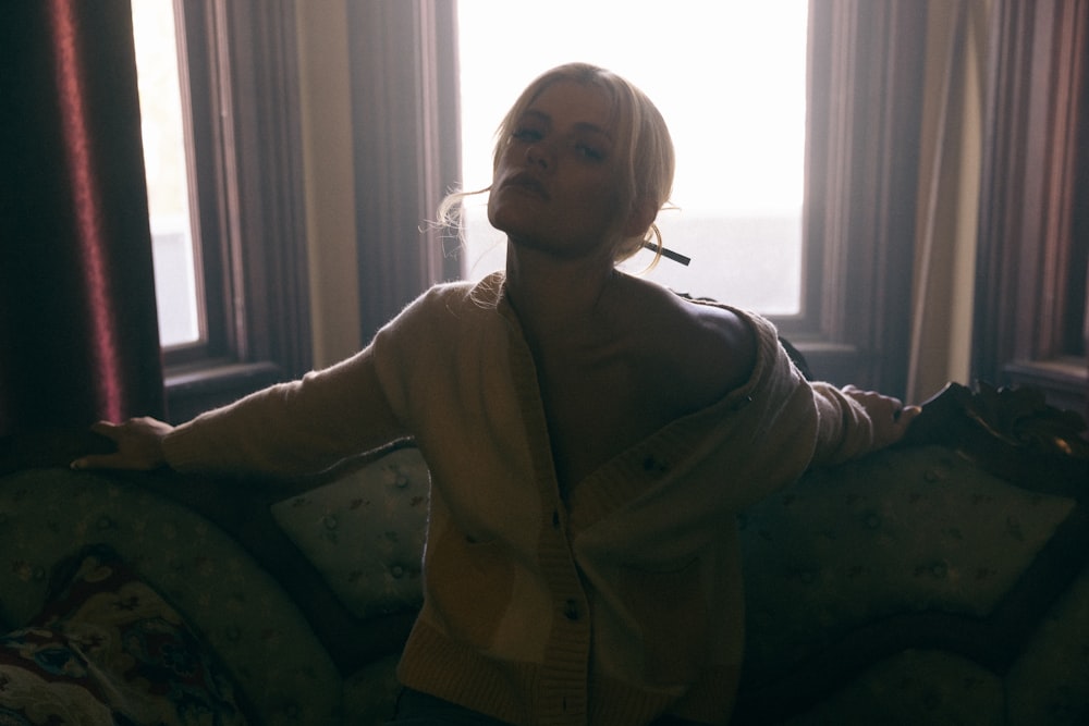 woman in white button up jacket sitting on sofa