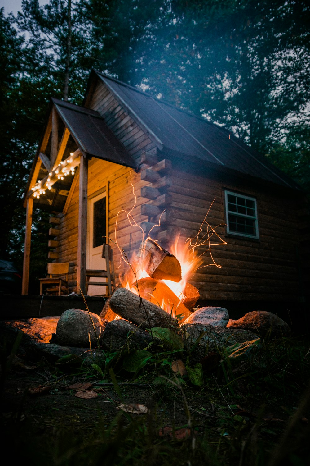 brown wooden house with fire during night time