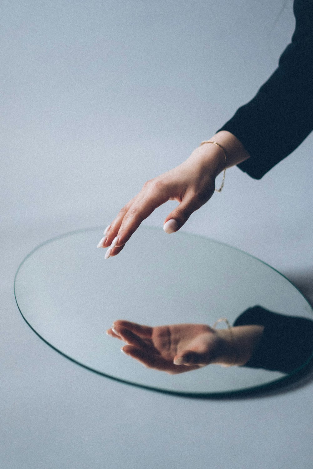 person in black long sleeve shirt holding round glass