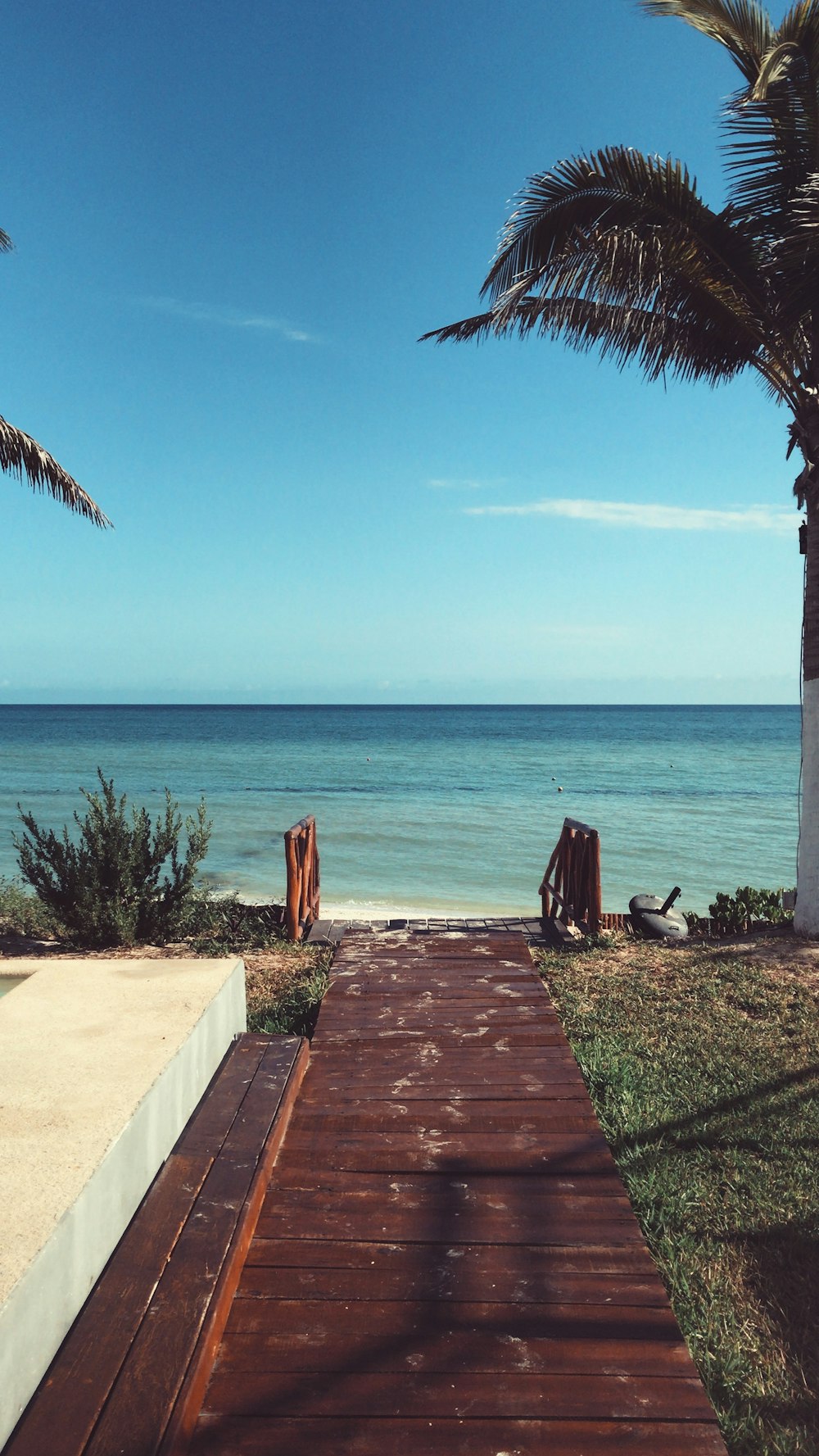 brown wooden pathway on beach during daytime