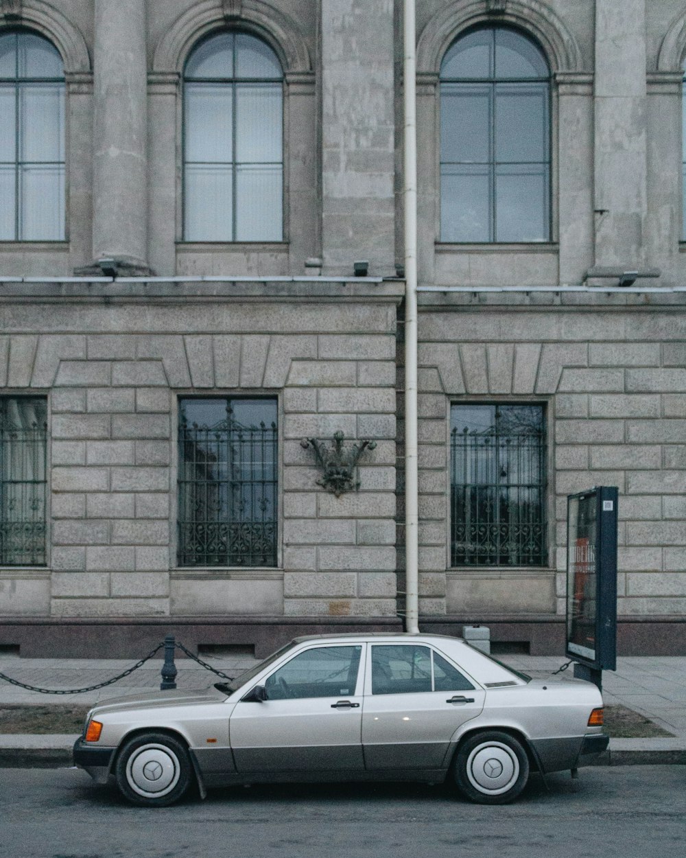 white sedan parked beside building during daytime