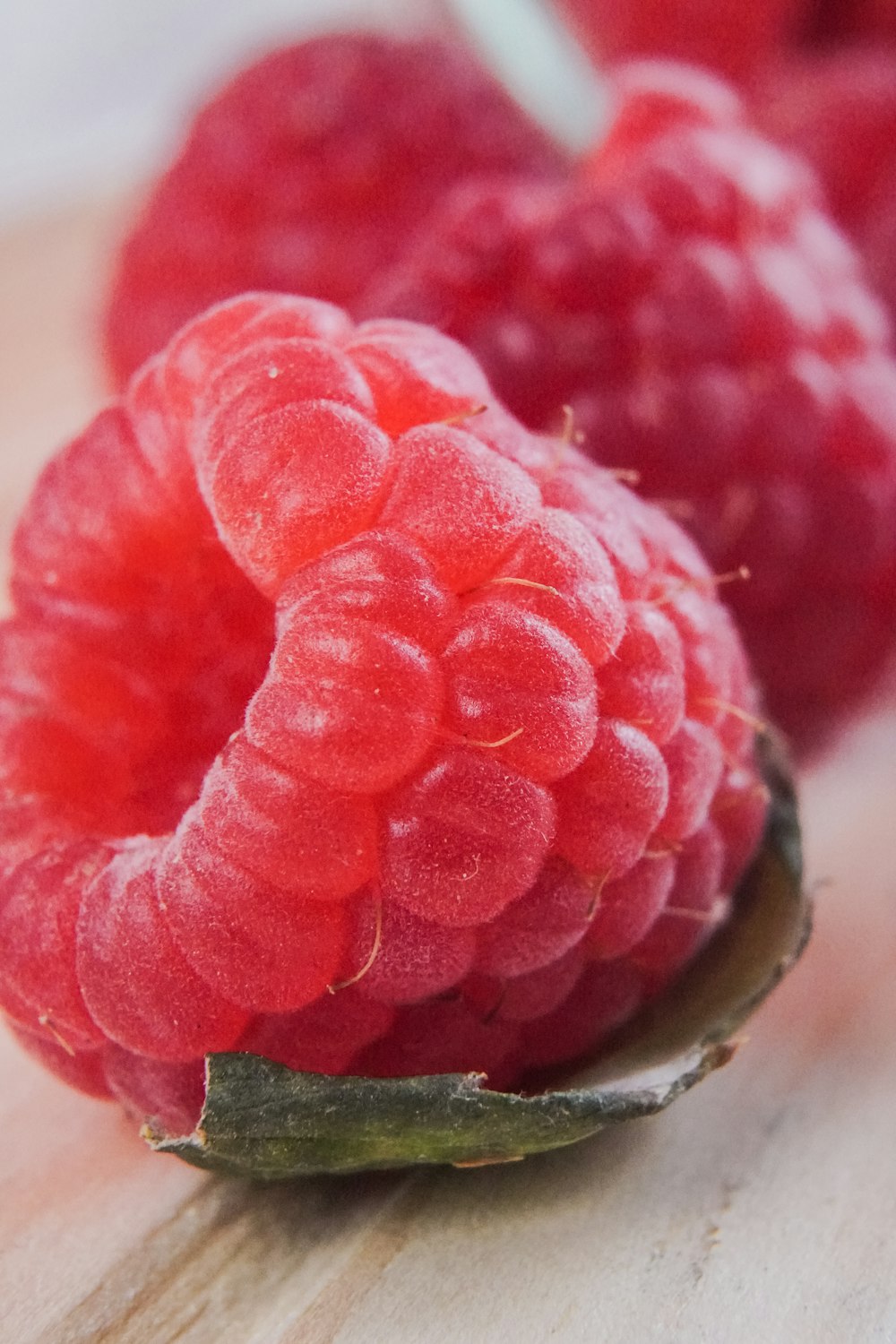 red raspberry on brown wooden table