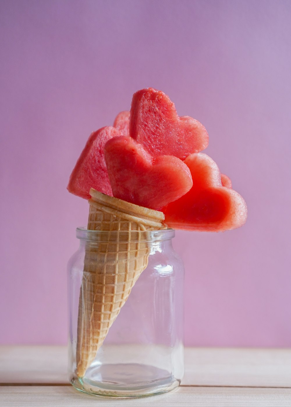 red and pink ice cream in clear glass jar