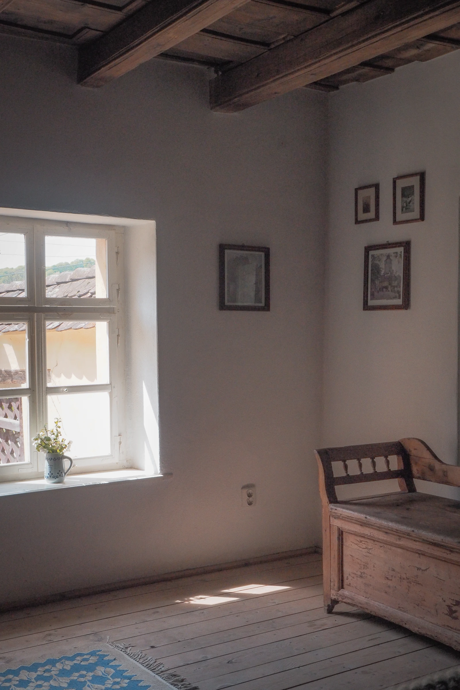 Pièce d'une maison de famille avec un banc ancien et des cadres