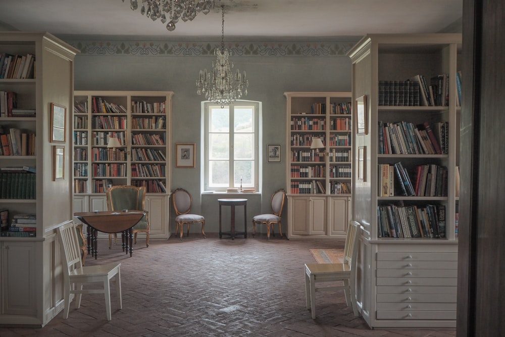 a room filled with lots of books and a chandelier