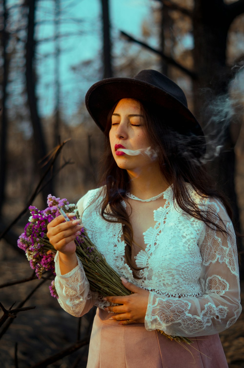 woman in white floral lace dress holding bouquet of flowers