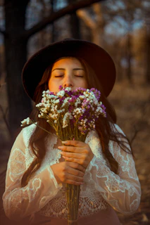 woman in white floral dress holding bouquet of flowers