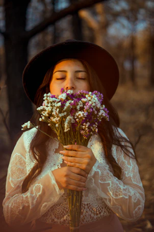 woman in white floral dress holding bouquet of flowers