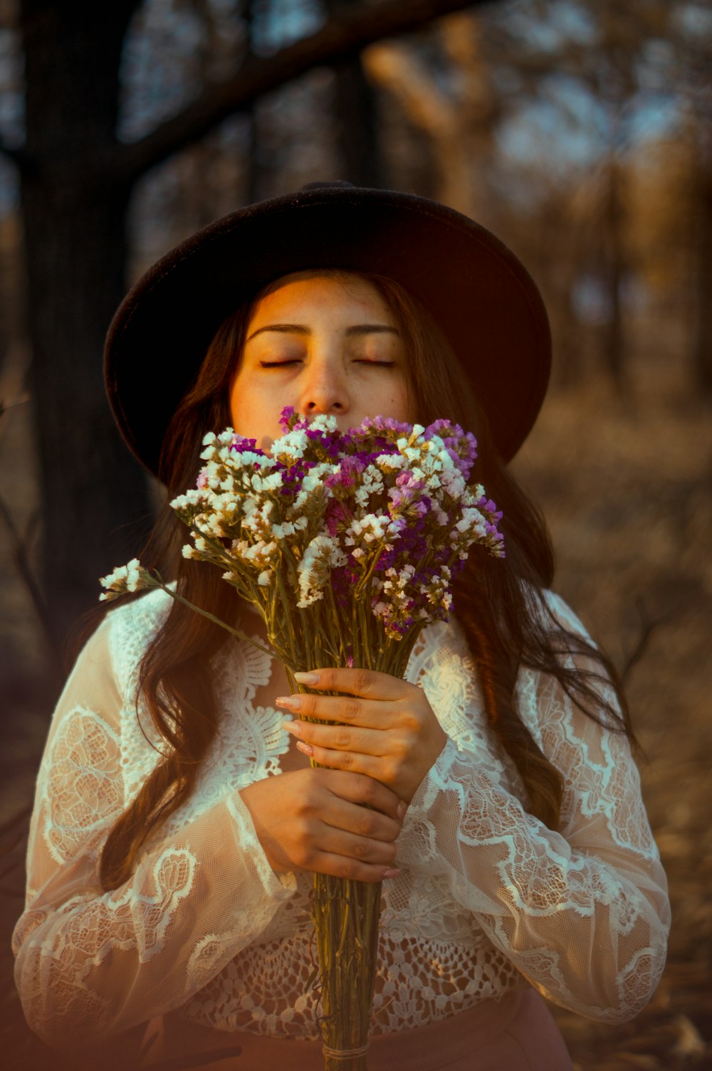 mujer en vestido floral blanco sosteniendo ramo de flores