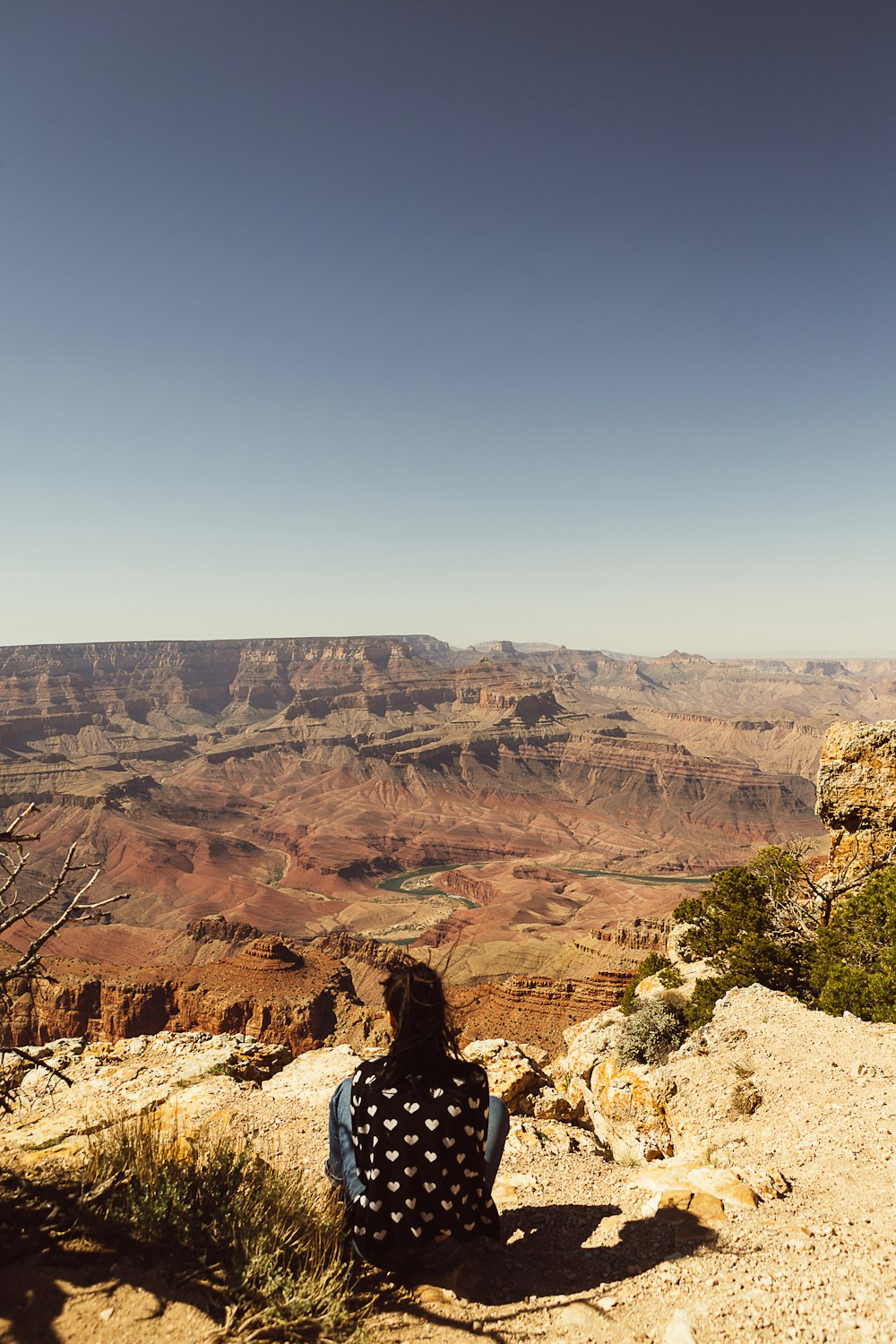 person sitting on rock formation during daytime