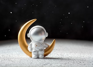 A glowing astronaut silhouette standing on a cratered moon surface under a starry sky.