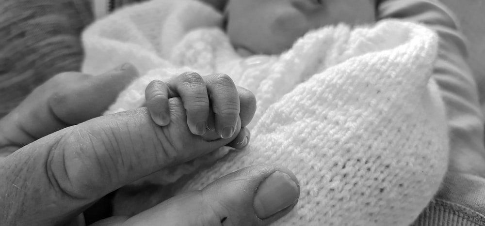 babys feet on white textile