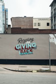 a sign on the side of a building advertising giving back