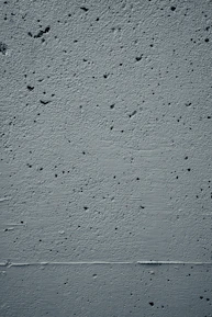 Close-up texture of smooth concrete wall with subtle shadows.