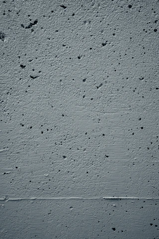Close-up texture of smooth concrete wall with subtle shadows.