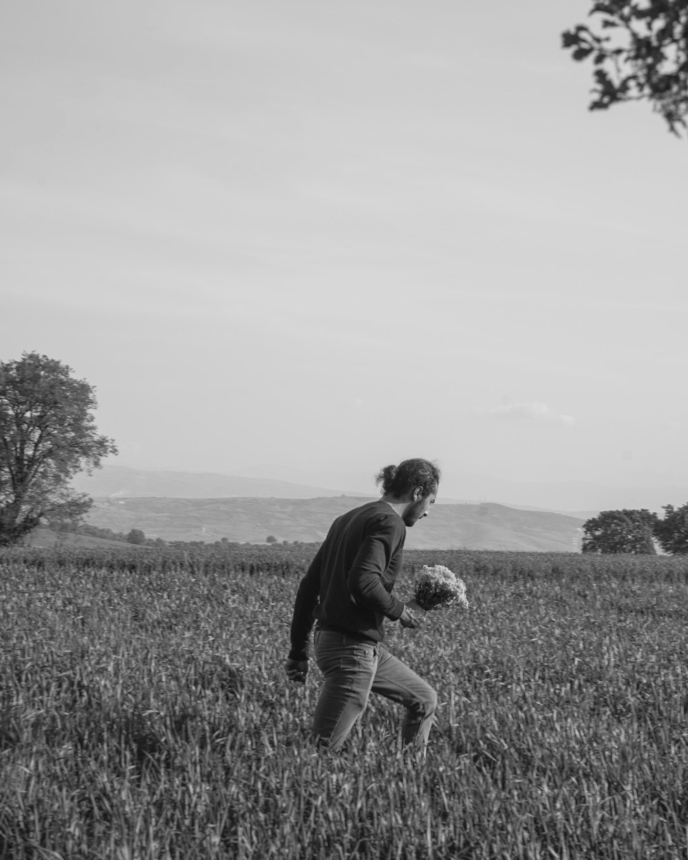 man in black jacket and pants sitting on grass field