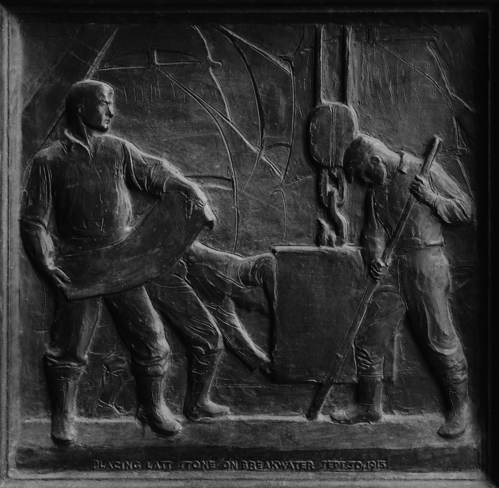 man and woman sitting on bench statue