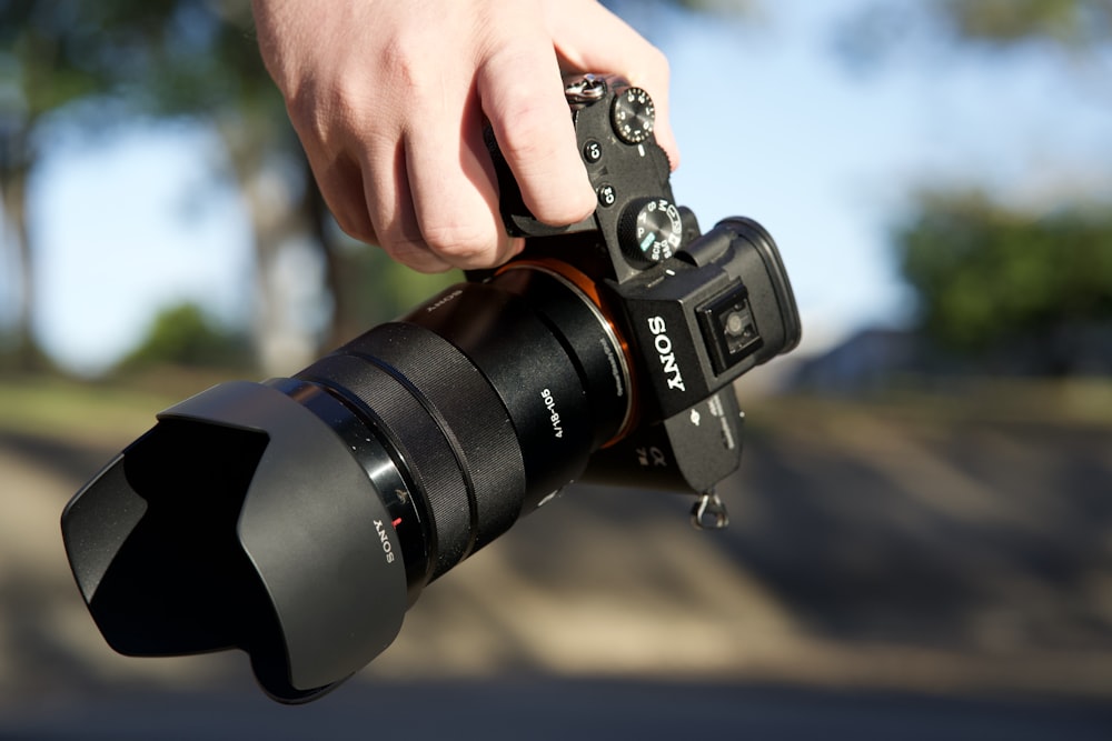 person holding black nikon dslr camera