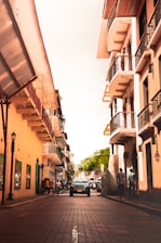 cars parked beside the road in between buildings during daytime