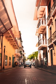 cars parked beside the road in between buildings during daytime